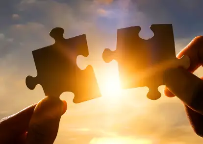 Hands connecting puzzle pieces, symbolizing private coaching and personal growth with Beatriz Martinez in Miami, FL.